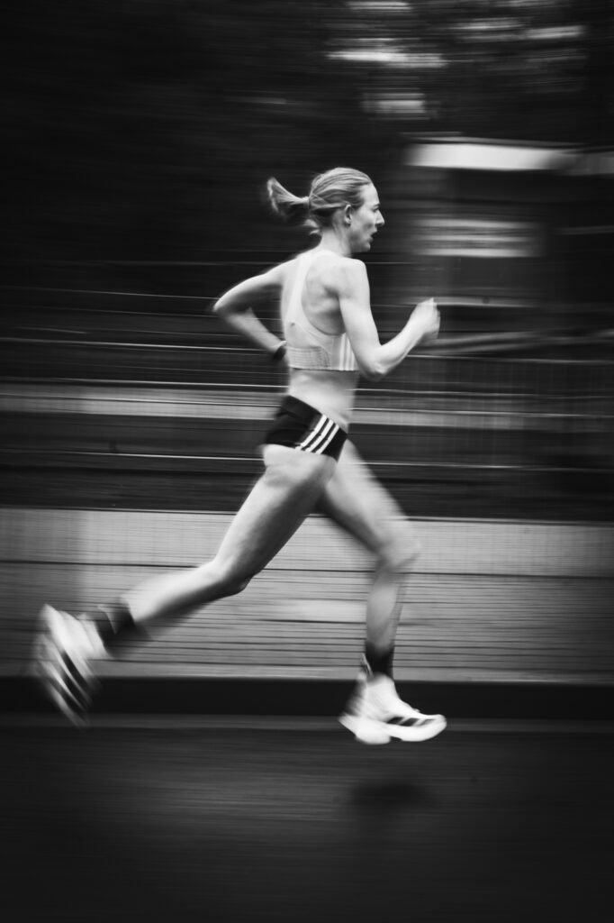 Sports and running photography by Łukasz Zając, black and white motion blur action shot of a runner training outdoors, Kraków, Poland