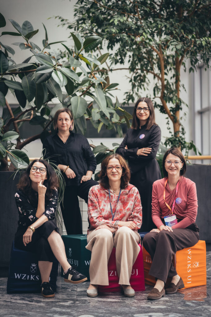 Corporate group portrait photography by Łukasz Zając, group of professionals posing amidst indoor greenery at the ICE Kraków Congress Centre in Kraków, Poland