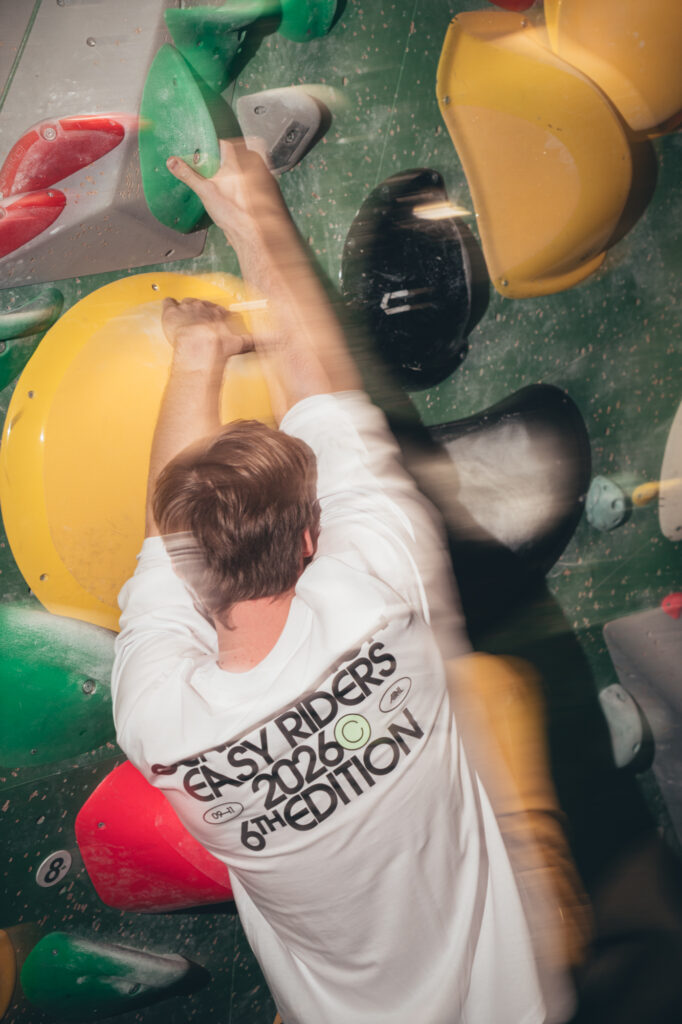 Sports and action photography by Łukasz Zając, overhead view of a climber navigating colorful holds on an indoor climbing wall, Poland