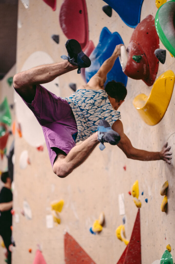 Sports and action photography by Łukasz Zając, dynamic shot of a climber scaling a colorful indoor climbing wall, Kraków, Poland