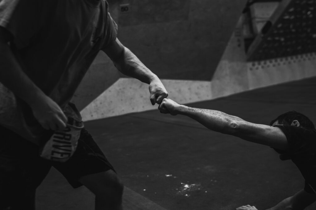 Sports and action photography by Łukasz Zając, black and white close-up of athletes fists bumping or shaking hands, Poland