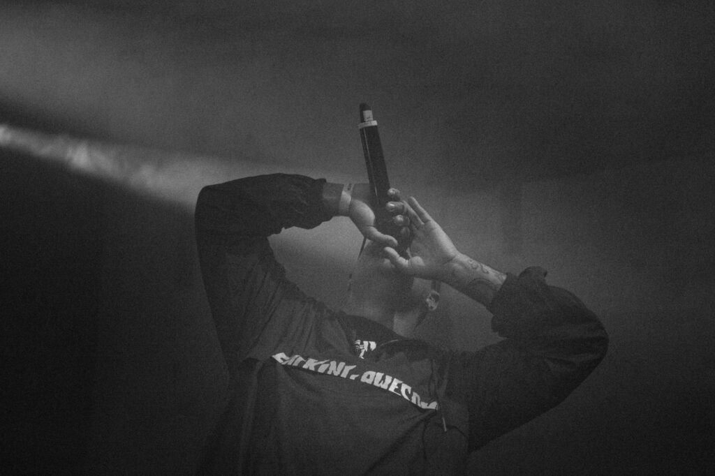 Culture and events concert photography by Łukasz Zając, performer holding a microphone on stage under stage lights, Kraków, Poland