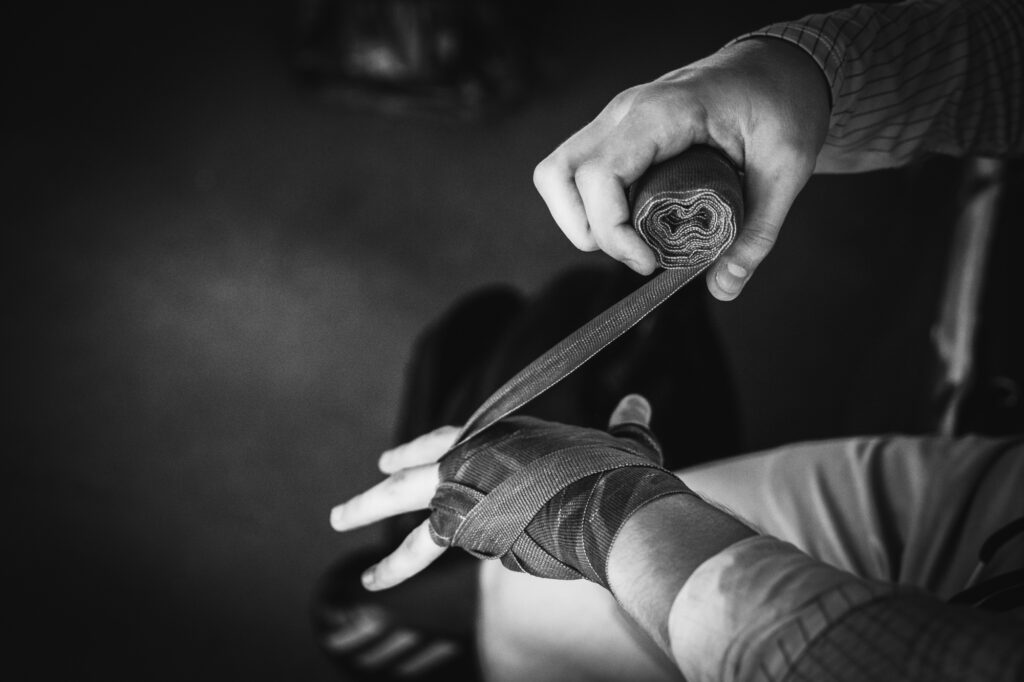 Sports and martial arts photography by Łukasz Zając, black and white close-up of a fighter wrapping hands with athletic tape, Poland