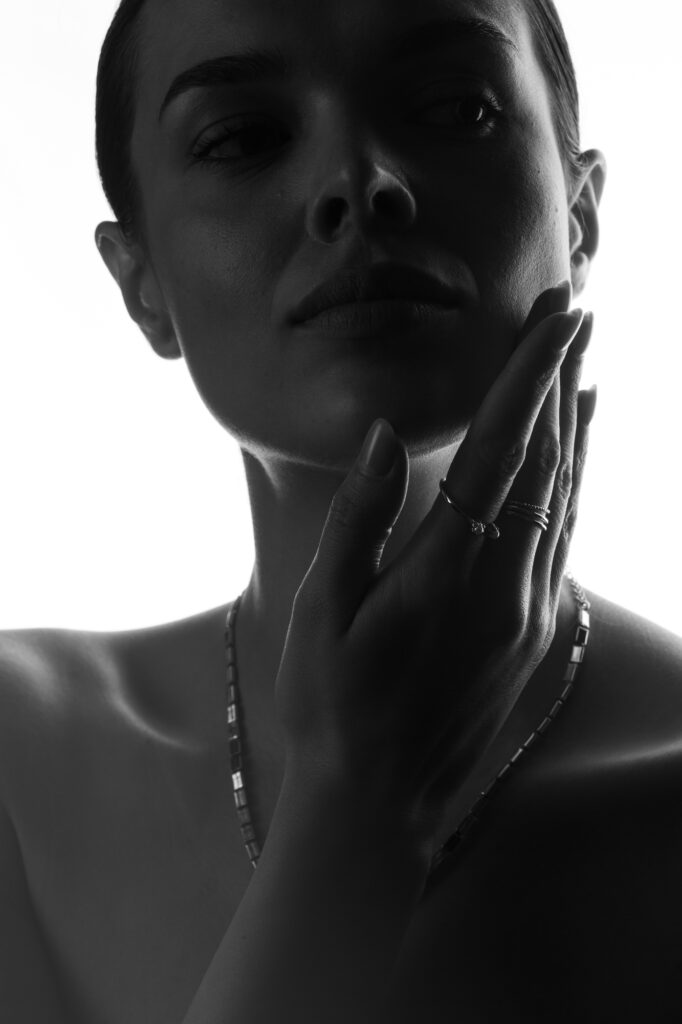 Commercial portrait photography by Łukasz Zając, woman with jewelry and delicate contrast lighting, Kraków, Poland